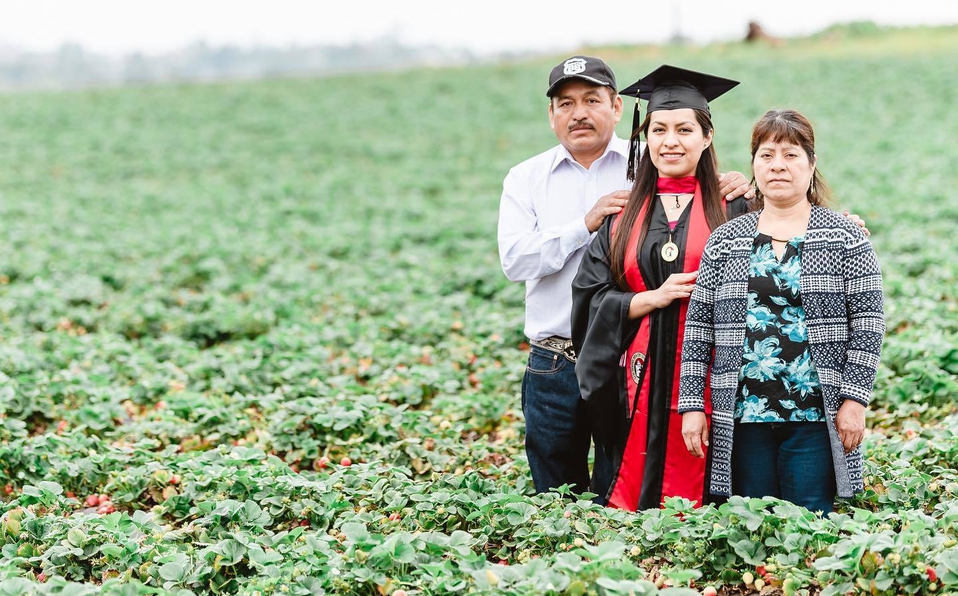 Migrante mexicana toma su foto de graduación en campo donde trabajaba
