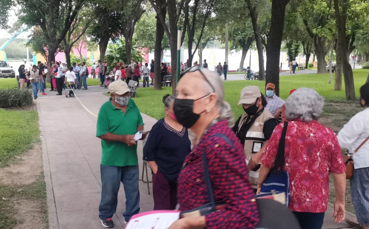 Forman largas filas en Parque España para cobrar apoyo de '68 y más'