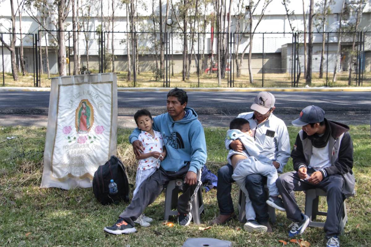 Un grupo de peregrinos descansan frente a la planta de Volkswagen en Puebla / Melanie Torres