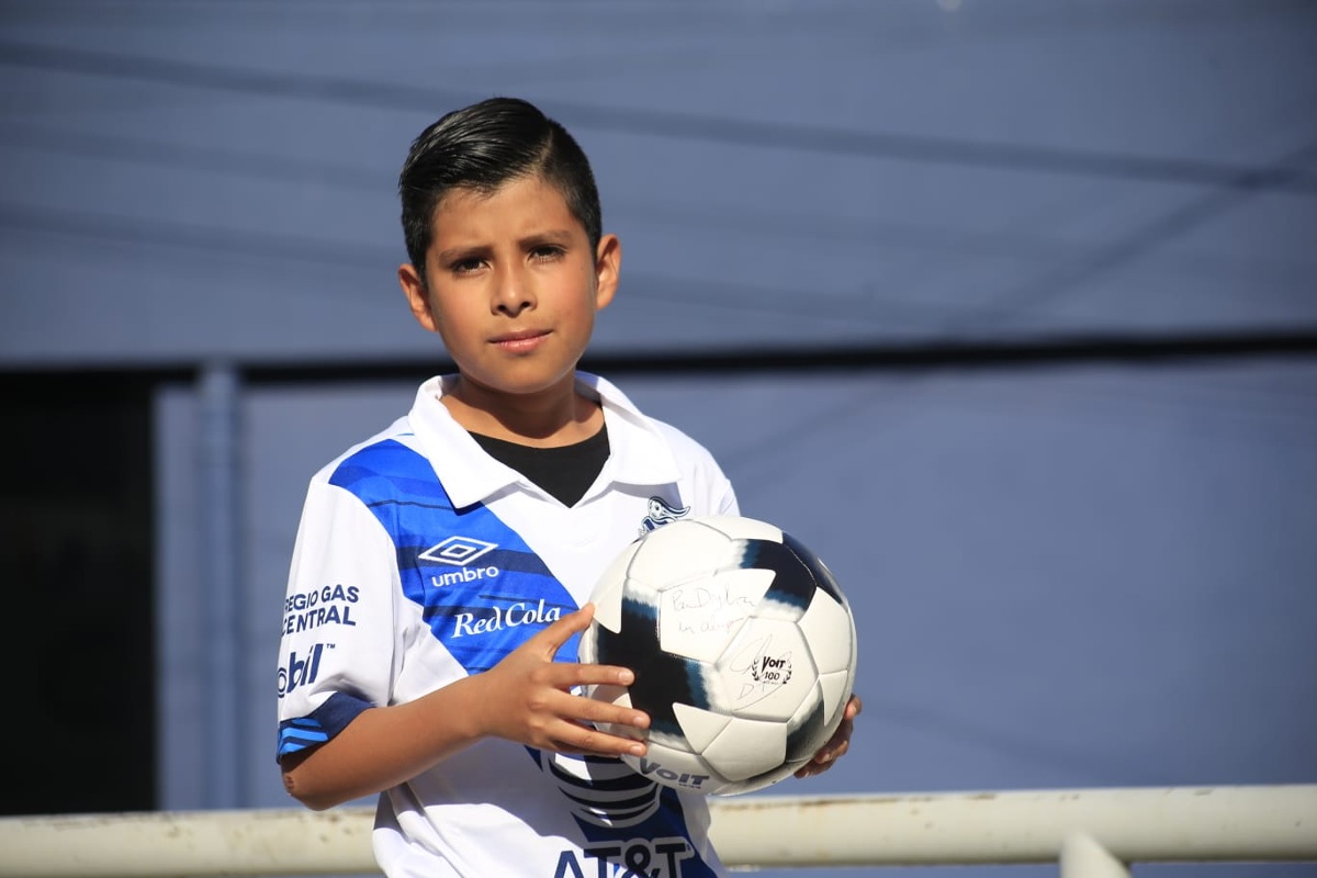Dylan sostiene un balón autogfrafiado por jugadores del Puebla que le fue obsequiado / Andrés Lobato