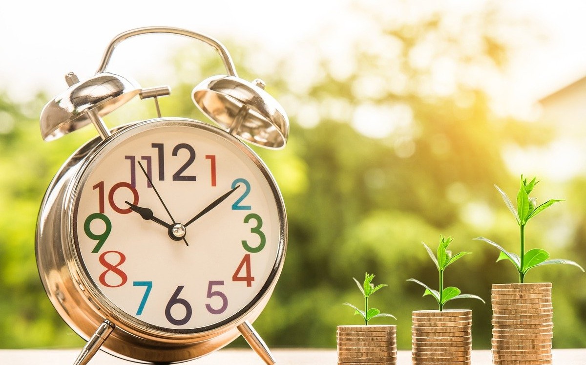 Reloj con monedas que simulan crecer plantas / Pixabay