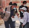 un adulto mayor pide ayuda a un hombre para la vacuna covid