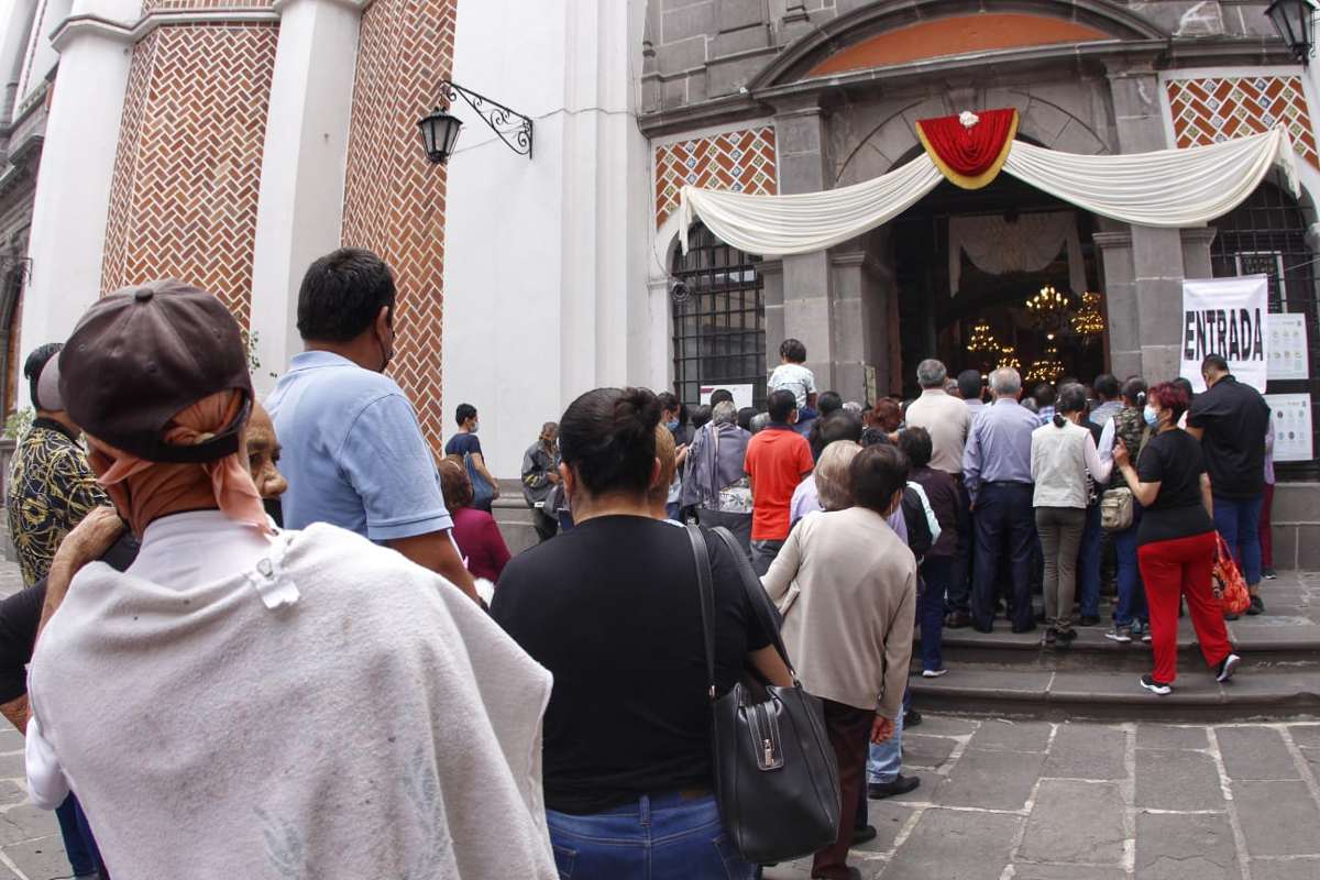 Personas esperan ingresar a la iglesia de la Virgen del Carmen / Melanie Torres