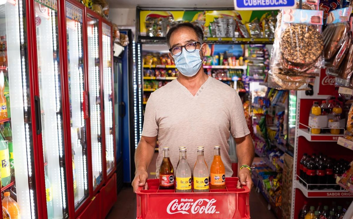 Señor sostiene refrescos en tiendita/ Archivo