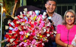 Alcalde morenista entrega enorme ramo de rosas y billetes a su esposa.