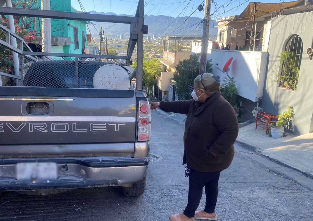 Una vecina señala el daño a un faro de una camioneta. | Frida Rodríguez
