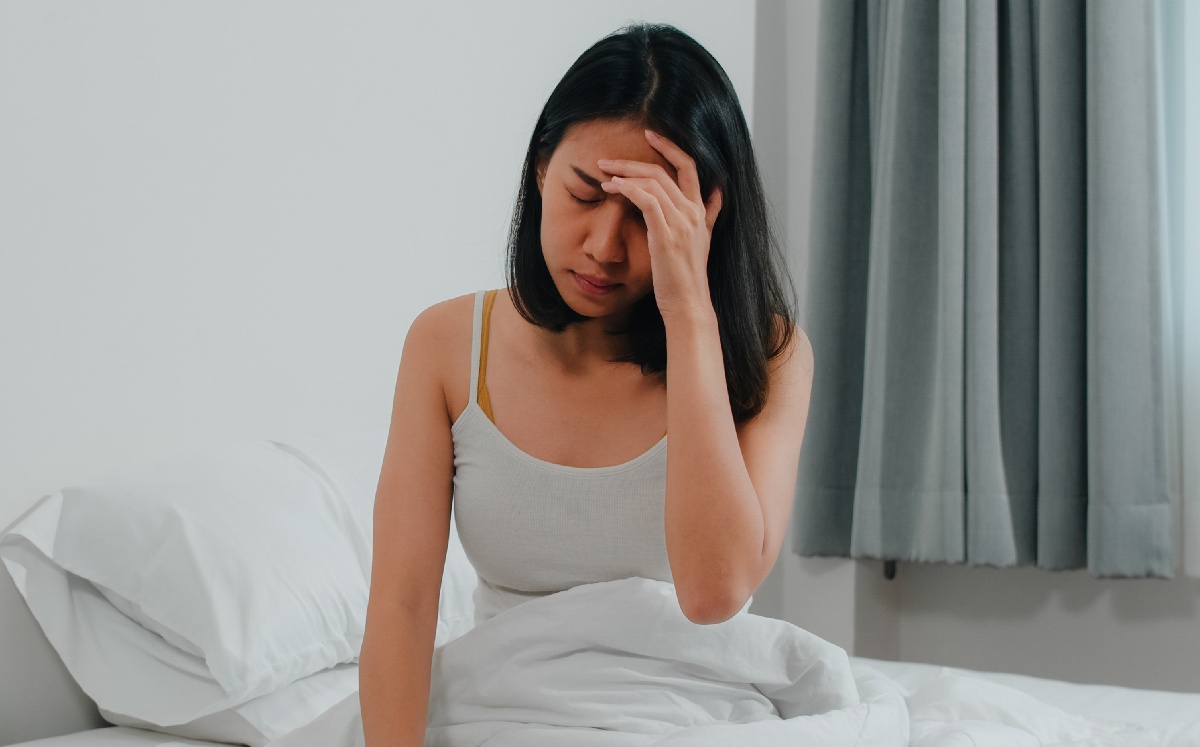 Persona sentada en una cama / Freepik