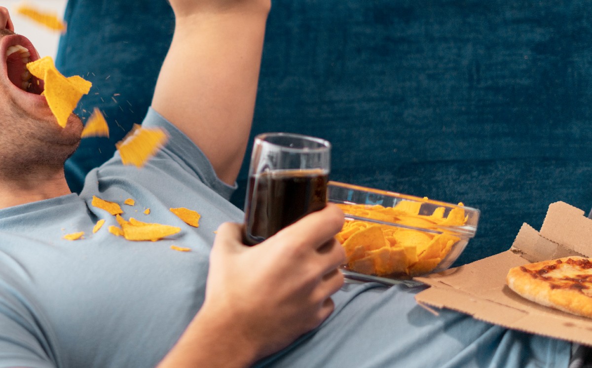 Persona ingiriendo comida rápida / Freepik