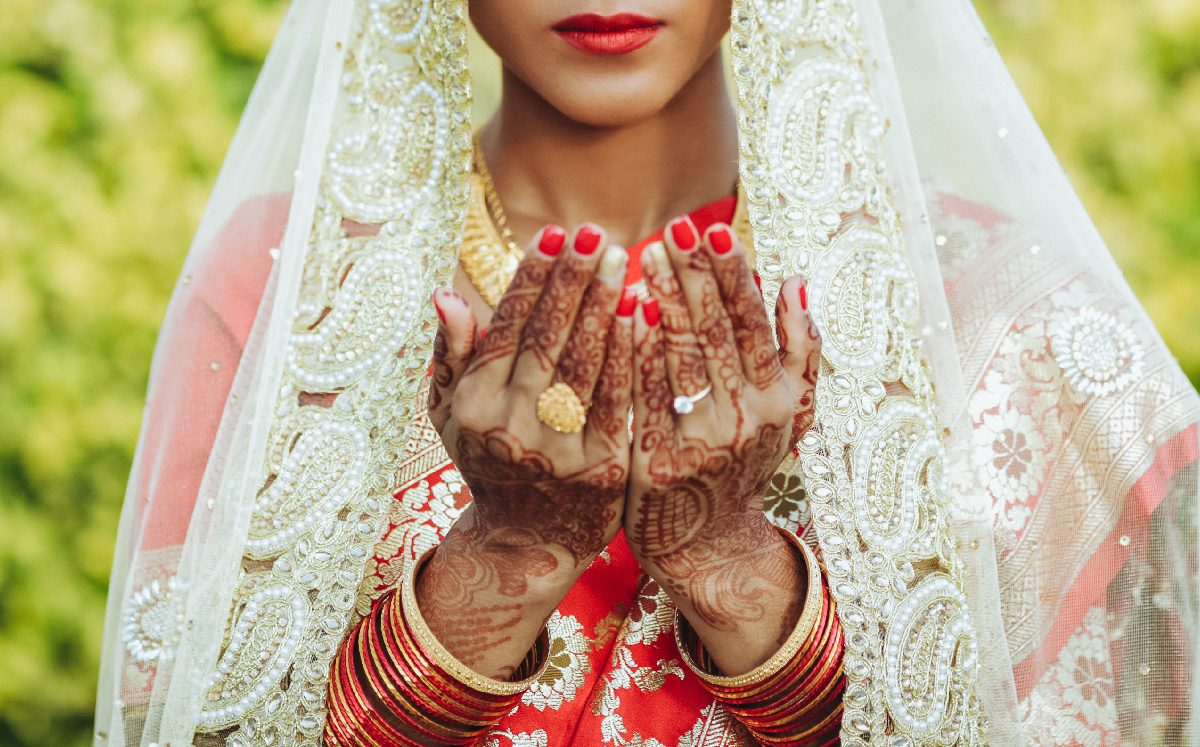 Novia hindú con velo blanco levanta sus manos / Freepik