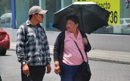 personas usando una sombrilla para cubrirse del sol