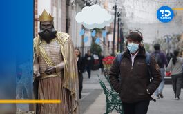 un chico con cubrebocas y audífonos abrigado