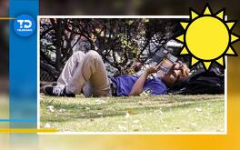 un hombre acostado en el pasto leyendo