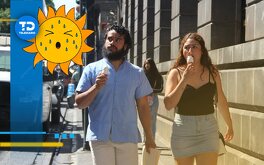 un hombre y una mujer comiendo un helado mientras caminan por una calle
