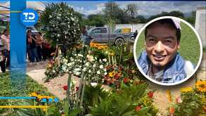 un sepulcro con flores y la foto de un hombre