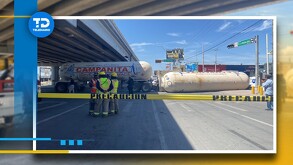 Conductor de una pipa de gas de doble remolque no toma precaución y vuela al dar la vuelta, dos personas resultan con golpes leves.