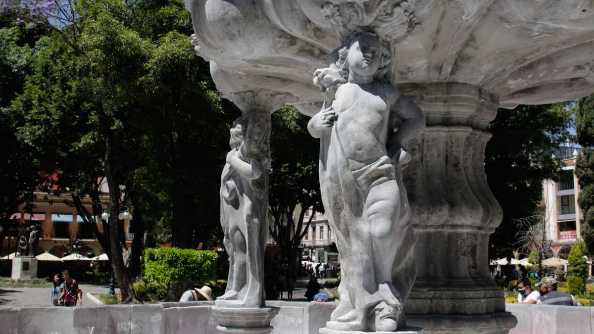 Cuatro querubines sostienen la pileta sobre la que se erige la figura de San Miguel Arcángel en la fuente del Zócalo de Puebla | Es Imagen