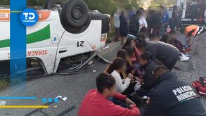 personas lesionadas sentadas en una carretera tras un accidente en una camioneta