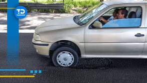 un automóvil pasando por un hoyo en una carretera