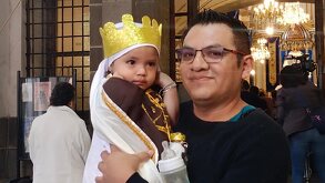 un hombre carga a su hija pequeña en una iglesia