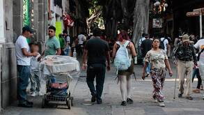 personas caminando en una calle con puestos ambulantes
