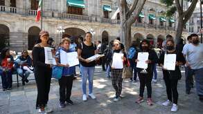 personas muestran documentos de propiedades durante una protesta