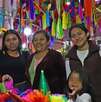 una familia muestra piñatas navideñas en un mercado