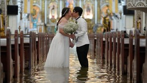 Una pareja filipina conmueve al casarse en una iglesia inundada durante un tifón, simbolizando amor y resiliencia en medio de la adversidad climática.