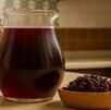 una jarra de agua de jamaica junto a flores de jamaica secas una jarra de agua de jamaica junto a flores de jamaica secas