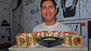 un hombre presenta un plato de suchi de chile en nogada
