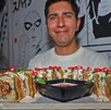 un hombre presenta un plato de suchi de chile en nogada