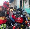 un niño arriba de una moto acompañado de un hombre con disfraz de elmo un niño arriba de una moto acompañado de un hombre con disfraz de elmo
