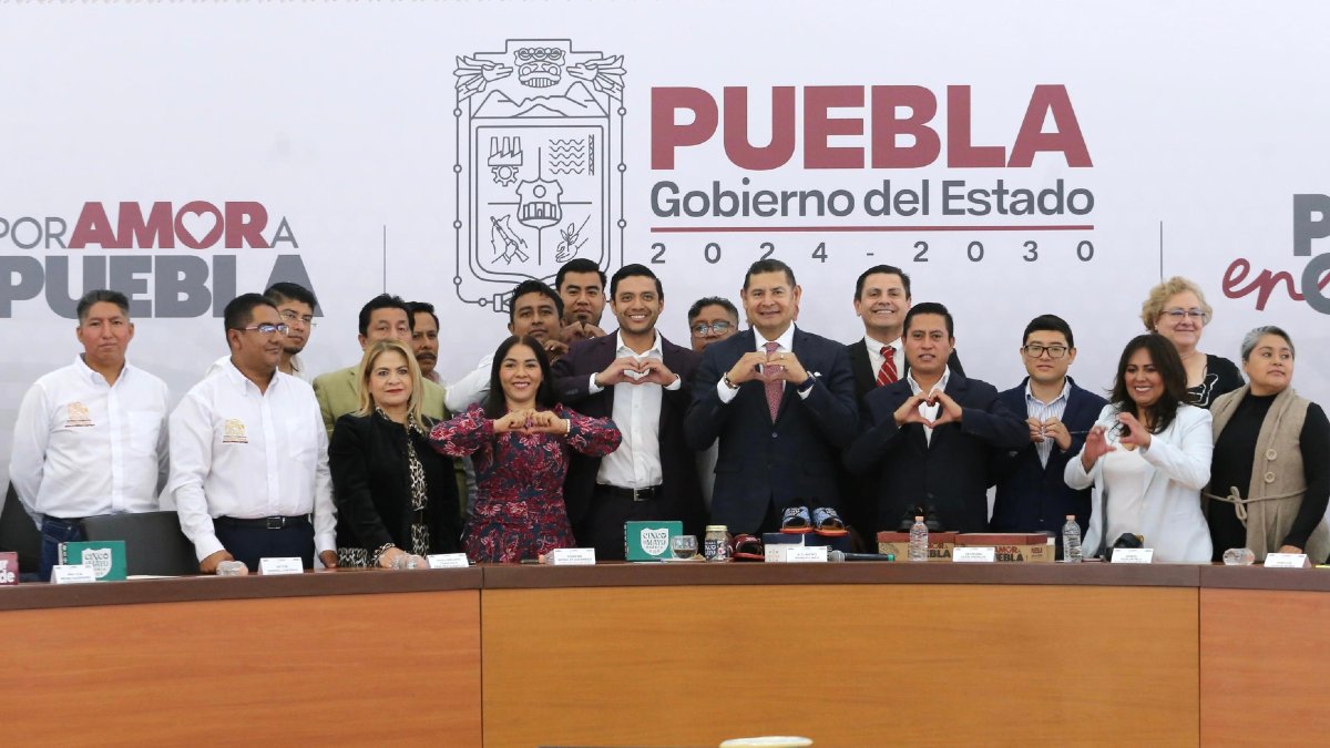 alejandro armenta acompañado de  personas en una conferencia de prensa