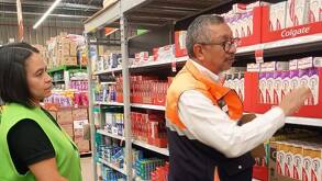 pesonas supervisan un producto en un supermercado