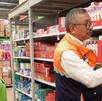pesonas supervisan un producto en un supermercado