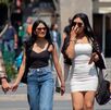 un chico y tres chicas caminan en un parque durante un día soleado