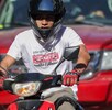 un hombre joven a bordo de una motocicleta en una calle