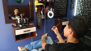 un hombre joven sentado en una silla de barbería