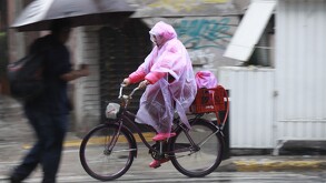 Ciudadanos conducen por avenidas inundadas este 25 de agosto.