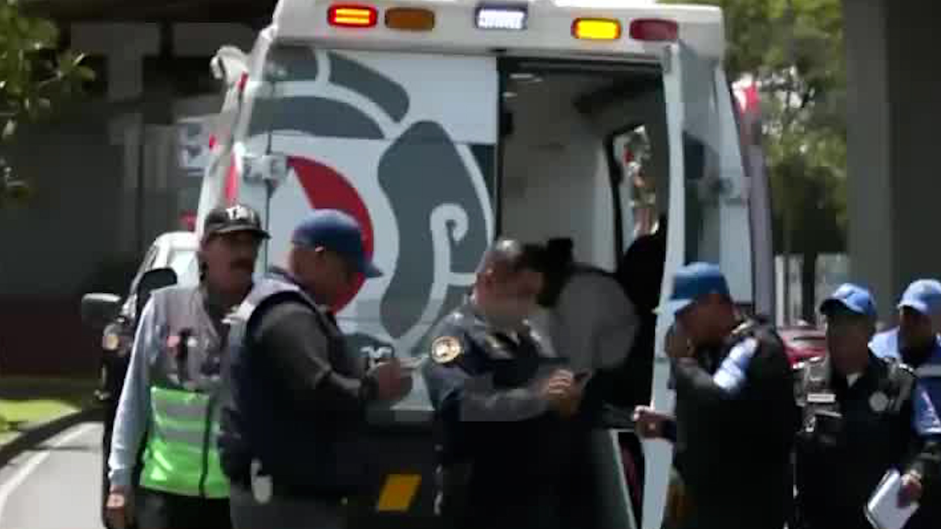 Servicios de emergencia laboran sobre viaducto para auxiliar a las tres personas a bordo del vehículo.