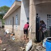 Con lágrimas en los ojos y acompañada de familiares y vecinos, pasó horas sacando lodo, piedras y agua de su hogar.