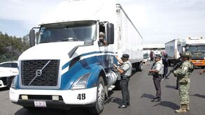 agentes de la guardia nacional supervisando un tráiler
