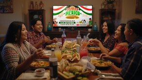 una familia mexicana cenando comida mexicana viendo el grito de independencia