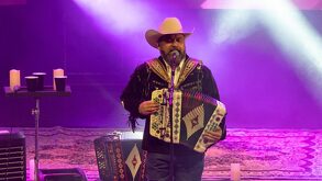 un cantante con un acordeon cantando en un concierto