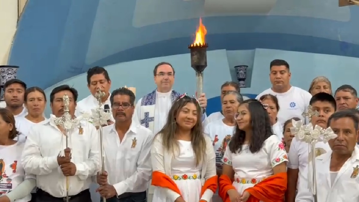 jóvenes y un sacerdote con la antorcha guadalupana