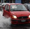 un carro circulando por una calle inundada