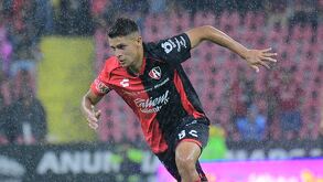 Mateo García disputando un partido bajo la lluvia con el equipo de Atlas.