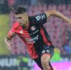 Mateo García disputando un partido bajo la lluvia con el equipo de Atlas.