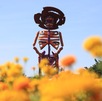 una escultura de una catrina monumental en un campo de cempasúchil