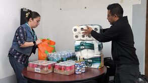 un hombre y una mujer recolectan víveres en un centro de acopio