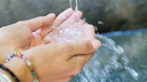 Manos de una persona bajo un chorro de agua potable que sale de una llave en la alcaldía Tlalpan. Presuntamente está contaminada.